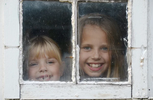 Meninas na janela velha — Fotografia de Stock