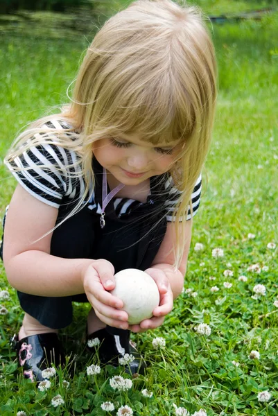 Chica sosteniendo un huevo de ganso —  Fotos de Stock