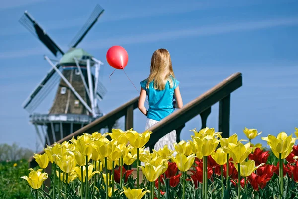 Girl with balloon by windmill — Stock Photo, Image