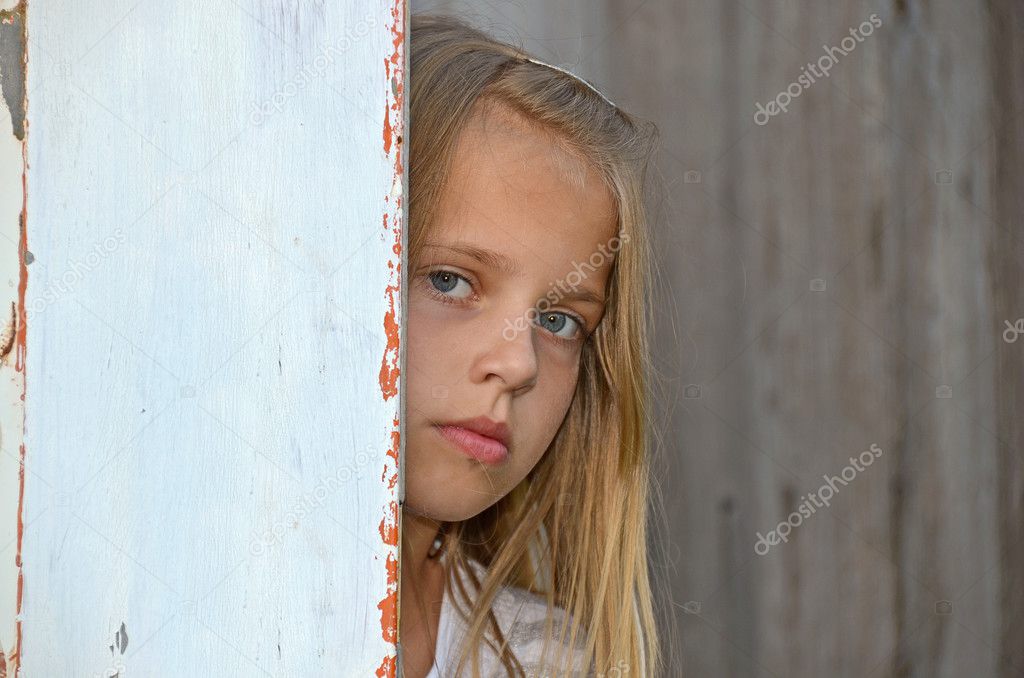 Girl peeking around old door
