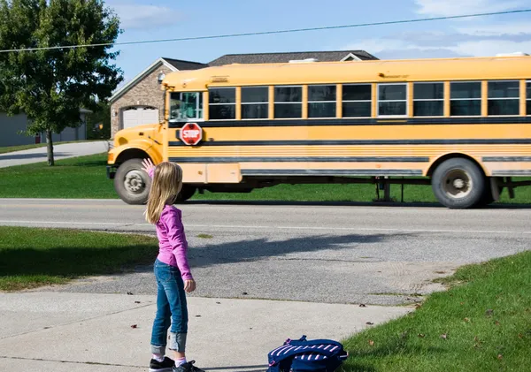 Criança acenando no ônibus escolar — Fotografia de Stock