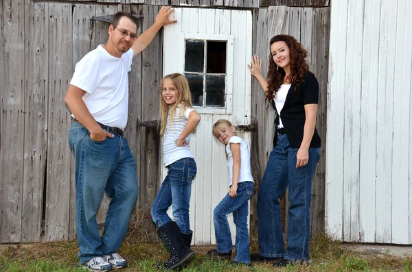 Family posing by an old barn — Stock Photo, Image
