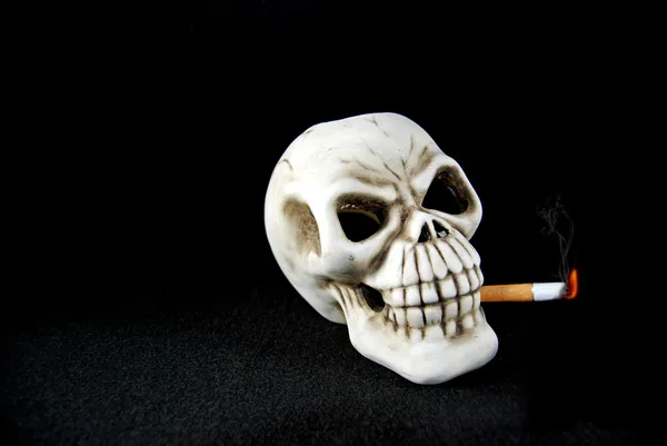 Череп курит сигарету — стоковое фото