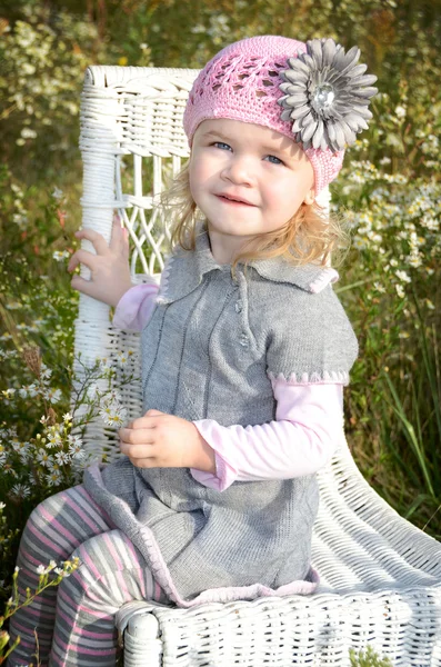 Маленька дівчинка на плетеному стільці — стокове фото