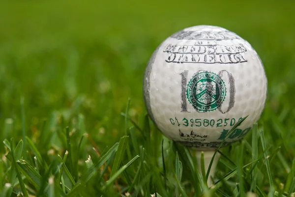 Geld op golfbal — Stockfoto