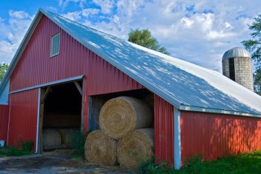 Rolled hay bales in barn clipart