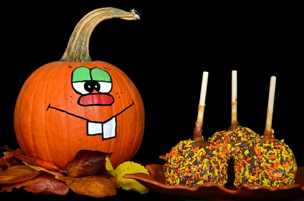 Pumpkin looking at caramel apples — Stock Photo, Image