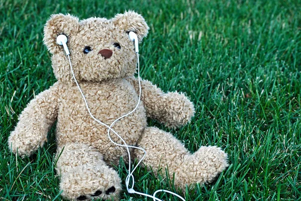 Медведь Тедди слушает музыку — стоковое фото
