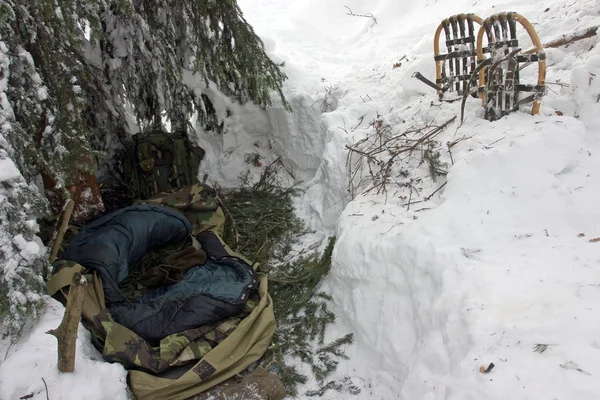 Dormir fuera en invierno - Bivouac bajo el árbol en una deriva de nieve —  Fotos de Stock