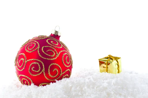 Una decorazione natalizia rossa e dorata sulla neve — Foto Stock