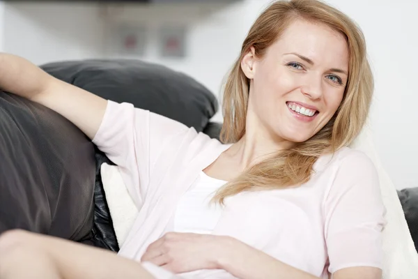 ソファの上に休む若い女性 — ストック写真
