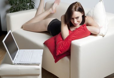 Kanepede dinlenen genç bir kadın.