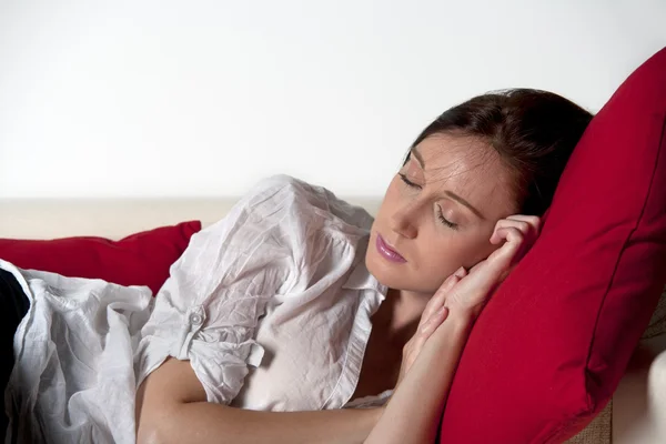 Mladá žena spí na pohovce — Stock fotografie
