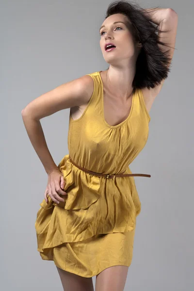 Genç kadın sarı akan içinde elbise — Stok fotoğraf