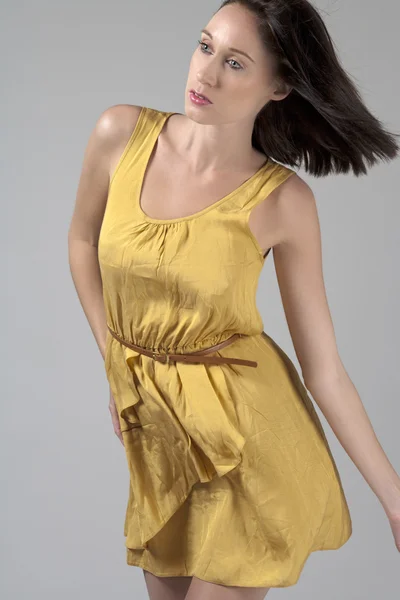 Młoda kobieta w płynie żółta sukienka — Zdjęcie stockowe