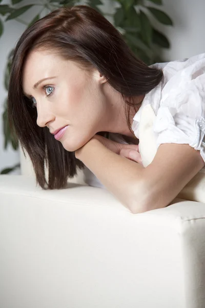 Young woman relaxing on a sofa — Stock Photo, Image