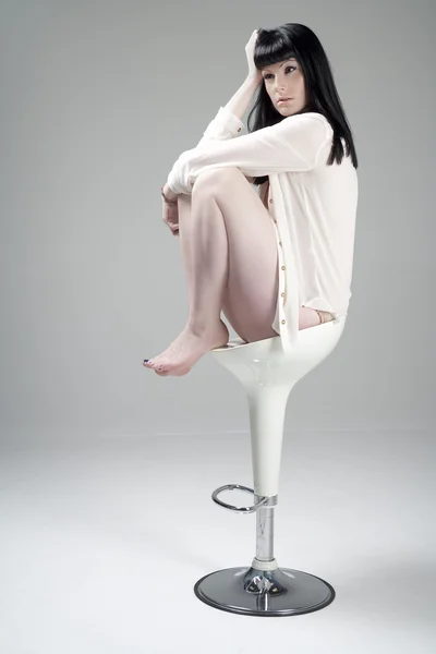 stock image Young woman sat on white stool