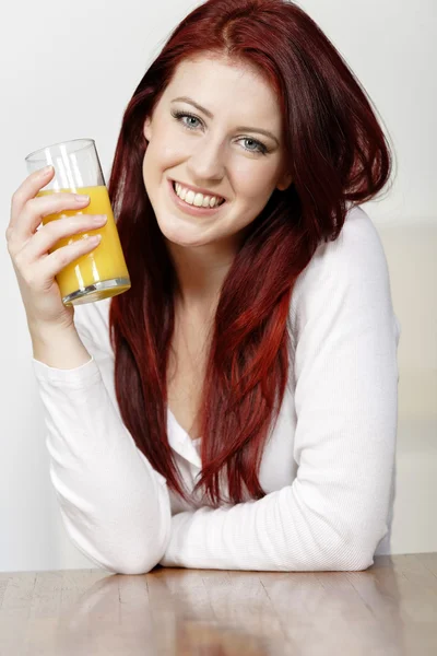 Mulher feliz com suco de laranja fresco — Fotografia de Stock