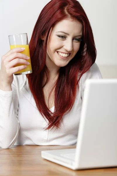 Szczęśliwy uśmiechający się włos w domu na laptopie — Zdjęcie stockowe