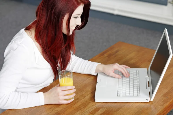 Glücklich lächelnde Frau zu Hause am Laptop — Stockfoto