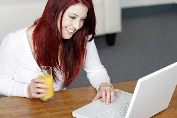 Felice donna sorridente a casa sul computer portatile — Foto Stock