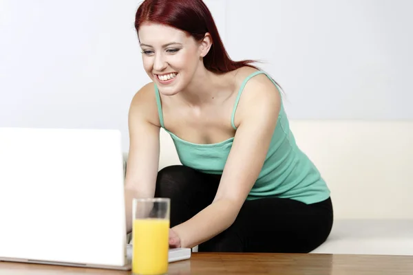 Evde dizüstü bilgisayar kullanan genç bir kadın. — Stok fotoğraf