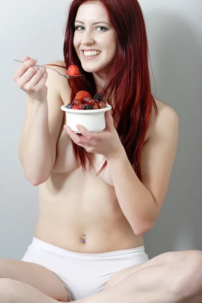 Kvinnan satt mot vägg äta frukt — Stockfoto