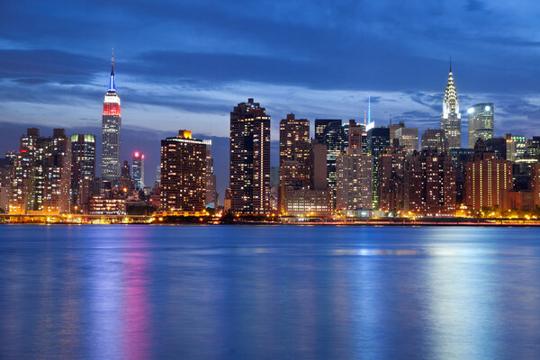 Image of the Manhattan skyline viewed from Queens at twilight.