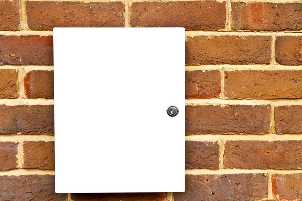 Locked white cupboard on a brick wall — Stock Photo, Image