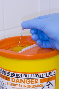 Sharps container and a hypodermic needle clipart
