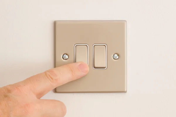 Double interrupteur sur un mur blanc étant pressé — Photo