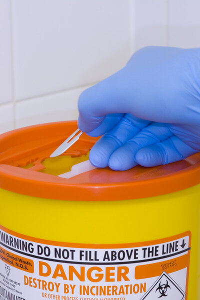 Sharps container and a scalpel blade