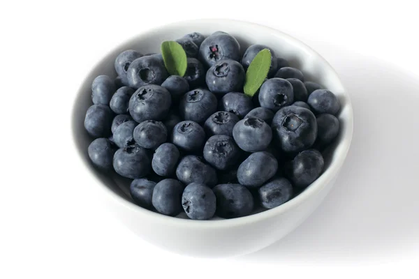 Blueberries with leaves in a cup — Stock Photo, Image
