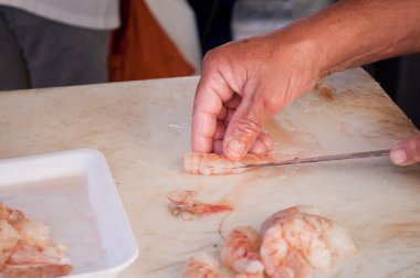 Close of a fisherman cleaning shrimp clipart