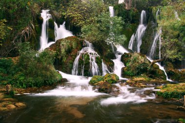 Serene waterfall cascades in wilderness clipart
