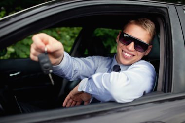 Young man buying new car, smiling clipart