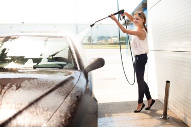 Young woman washing the car clipart