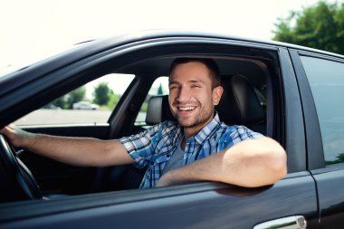 Young man in car smiling clipart