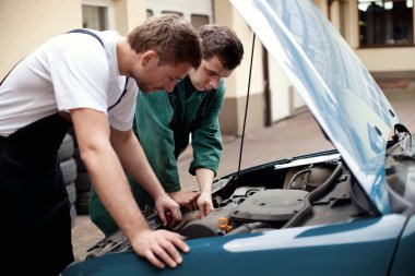 Two auto mechanics working with car clipart