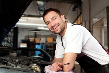 Mechanic based on car smiling clipart