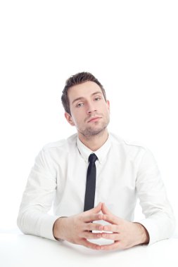 Young Businessman sitting at the desk with serious face clipart