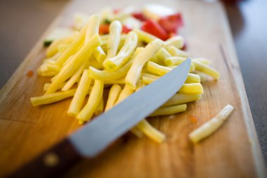 Yellow runner beans on cutting board and knife. Selective focus clipart