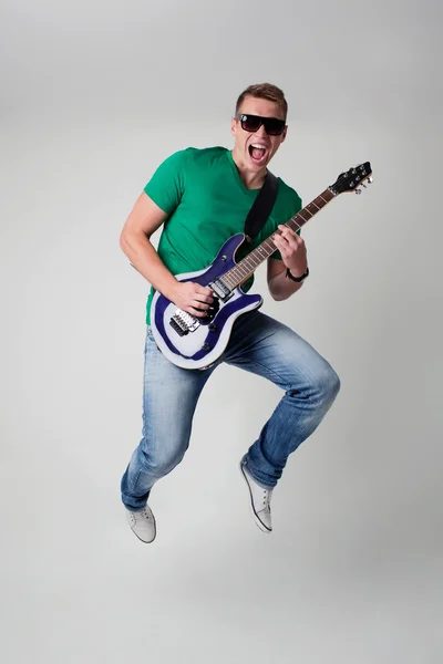 Rockstar leaping with guitar — Stock Photo, Image