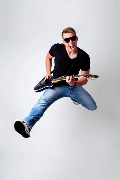 Rockstar leaping with guitar — Stock Photo, Image