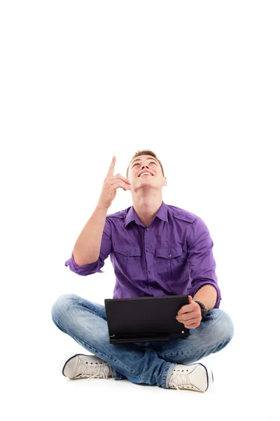 Young student with laptop sitting and looking up — Stock Photo, Image