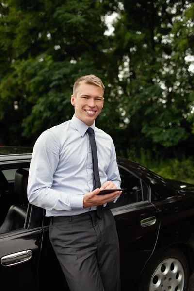 Man with ebook reader with his car — Stock Photo, Image