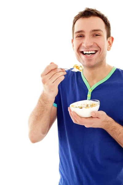 Joven hombre sonriente comiendo musli — Foto de Stock