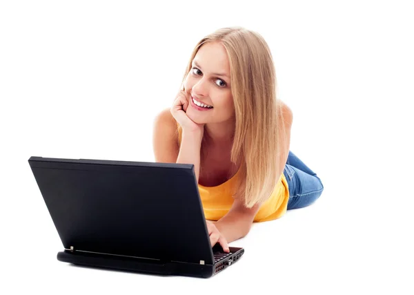 Junge Frau legt sich mit Laptop hin. — Stockfoto
