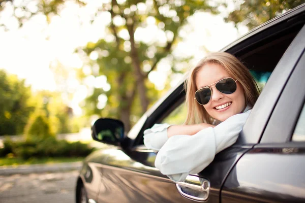 Молодая женщина в своей новой машине — стоковое фото