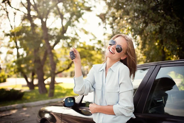 Młoda kobieta pokazuje klucze do jej nowego samochodu — Zdjęcie stockowe